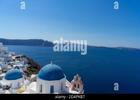 Vue sur Santorini, avec une église à dôme bleu typique, la mer et la caldeira de santorini Banque D'Images