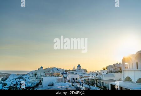 Vue panoramique sur la ville d'Oia sur l'île de Santorin avec d'anciennes maisons blanchies à la chaux et un moulin à vent traditionnel, Grèce. Paysage grec au coucher du soleil Banque D'Images