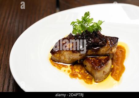 Foie gras grillé, canard grillé et volaille vivante d'oie, sauce prune salée. Cuisine internationale gastronomique à base de plats et boissons sous forme de buffet Banque D'Images