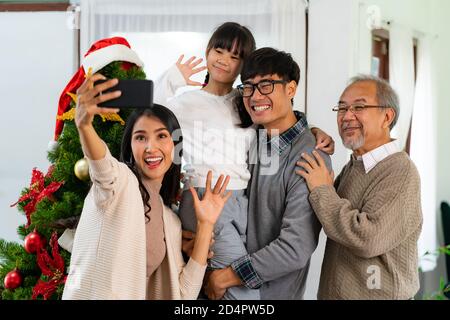 Famille asiatique multigénérationnelle, fille de maman papa fille et grand-père, selfie Avec un arbre de Noël après décorer l'ornement de Noël préparer mers Banque D'Images