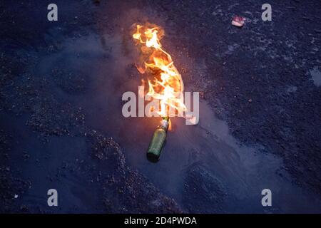 Une bombe à feu Molotov cocktail brûlante vue sur le sol pendant la démonstration. Des manifestations et des manifestations ont éclaté le week-end au Chili après que des vidéos aient été filmées montrant un policier des forces spéciales de Carabinero qui a poussé un jeune de 16 ans à descendre du pont Pio Nono à Santiago. Vers la fin de l'après-midi de vendredi, les infirmières techniciens, qui protestent depuis un mois pour une reconnaissance professionnelle, l'amélioration des conditions de travail et l'augmentation des salaires, ont été rejoints par une manifestation spontanée de centaines de jeunes, de groupes autochtones et d'autres groupes sociaux à l'approche d'un référendum pour rejeter le mili Banque D'Images