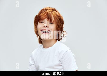 redhead garçon large sourire court vue blanc t-shirt gros plan studio Banque D'Images