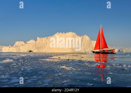 Bateau à voile rouge devant les icebergs, Icefjord, patrimoine mondial de l'UNESCO, baie de Disko, Ilulissat, ouest du Groenland, Groenland, Amérique du Nord Banque D'Images