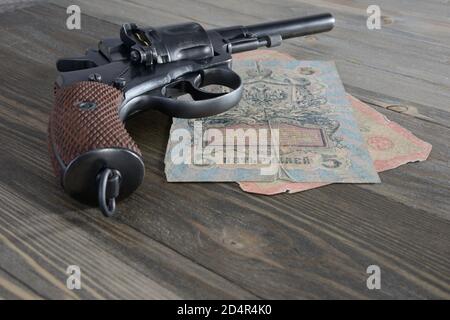 Billets et revolver de la Russie impériale sur une ancienne table en bois Banque D'Images