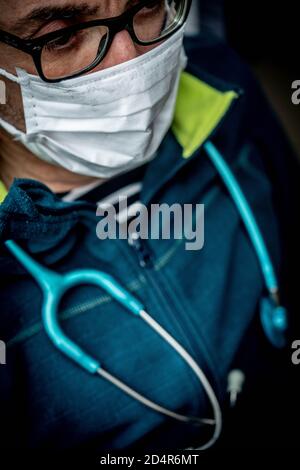 Médecin portant un masque de protection respiratoire pendant la consultation médicale, France. Banque D'Images