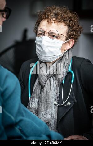 Médecin portant un masque de protection respiratoire pendant la consultation médicale, France. Banque D'Images