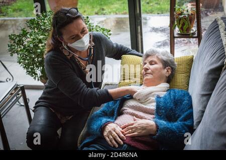 Médecin portant un masque de protection respiratoire pendant la consultation médicale, France. Banque D'Images