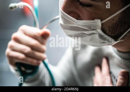 Médecin portant un masque de protection respiratoire pendant la consultation médicale, France. Banque D'Images