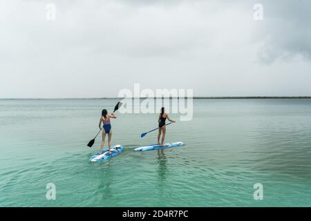 Les femmes pratiquant la paddle debout (SUP). Banque D'Images