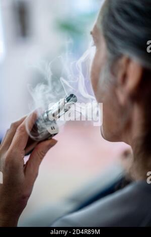 Femme à l'aide de la cigarette électronique. Banque D'Images