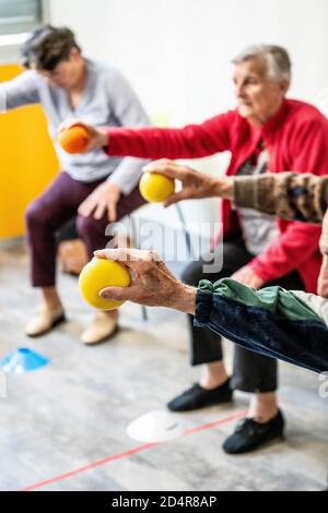 Programme d'exercice physique animé par un entraîneur et supervisé par Une infirmière Asalée dans le cadre des soins généraux de le sujet âgé de maintenir son a Banque D'Images