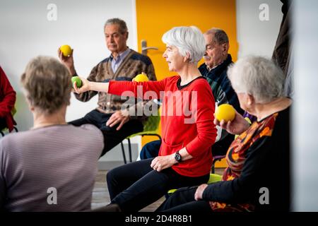 Programme d'exercice physique animé par un entraîneur et supervisé par Une infirmière Asalée dans le cadre des soins généraux de le sujet âgé de maintenir son a Banque D'Images