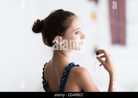 fille de 12 ans appliquant le perfum. Banque D'Images