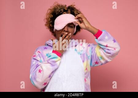 Bâillements de jeune femme africaine fatiguée en pyjama. Banque D'Images