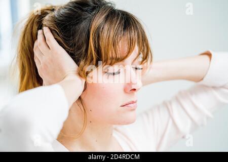La femme tient ses mains à ses oreilles douloureuses. Banque D'Images