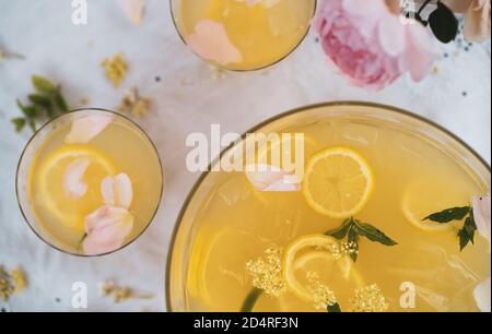 Bol de punch au citron avec deux verres et fleurs en été Banque D'Images