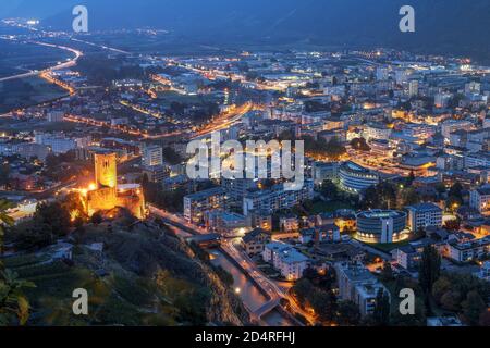 Vue aérienne de nuit de la ville de Martigny en Valais, Suisse. Le château de la Batiaz donne sur la scène. Banque D'Images