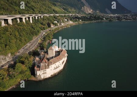 Vue aérienne du lac Léman (lac Léman) avec le célèbre château de Chillon, Suisse et l'autoroute suspendue qui passe juste au-dessus. Banque D'Images