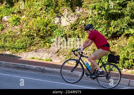 Ellicott City, MD, Etats-Unis 10/07/2020: Un homme caucasien âgé portant un casque monte à vélo dans la rue. Bien que cet homme âgé soit en forme, il est str Banque D'Images