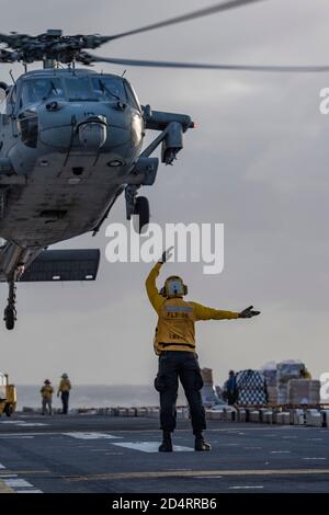 201006-N-NJ919-1281 MER DES PHILIPPINES (OCT 6, 2020) les marins affectés au navire d'assaut amphibie déployé à l'avant USS America (LHA 6) effectuent des opérations de vol pendant un réapprovisionnement en mer. L'Amérique, vaisseau amiral du America Expeditionary Strike Group, affecté à l'escadron amphibie 11, ainsi que la 31e unité expéditionnaire maritime, Opère dans la zone de responsabilité de la 7e flotte des États-Unis afin d'améliorer l'interopérabilité avec les alliés et les partenaires et de servir de force d'intervention prête à l'emploi pour défendre la paix et la stabilité dans la région Indo-Pacifique. (É.-U. Photo marine par Spécialiste communication de masse 3ème classe Banque D'Images