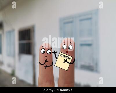 Deux doigts sont décorés pour deux personnes. L'un d'eux est un vendeur et il fait la promotion de ses produits. Banque D'Images