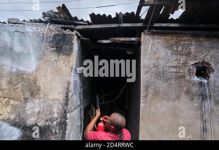 Une victime d'un accident d'incendie utilise un extincteur après l'explosion d'un camion chargé de gaz dans la capitale commerciale du Nigeria, Lagos, le 8 octobre 2020. Banque D'Images