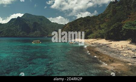 Vue aérienne de la croisière passager sur l'océan aux Philippines. Les gens sur les bateaux, bateau navigue à l'île El Nido de la baie de mer. Les touristes se reposent sur une plage de sable à l'eau tropicale de rivage. Paysage incroyable dans le paradis asiatique Resort Banque D'Images