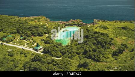 Lac d'eau salée Weekuri à l'île de Sumba vue aérienne. Tropic Resort à limpid loch avec la variété naturelle des Philippines. Attraction estivale épique avec bâtiments, route et voitures aux plantes tropicales vertes, arbres Banque D'Images