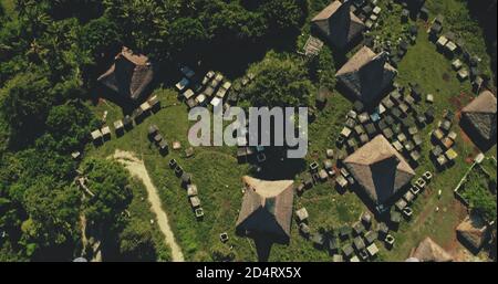 En haut d'un village unique avec des toits de paille maisons à la vallée verte vue aérienne. Nature tropicale sauvage avec chalets de tradition, grange sur chemin rural. Indonésie, île de Sumba point de repère de l'architecture ancienne Banque D'Images