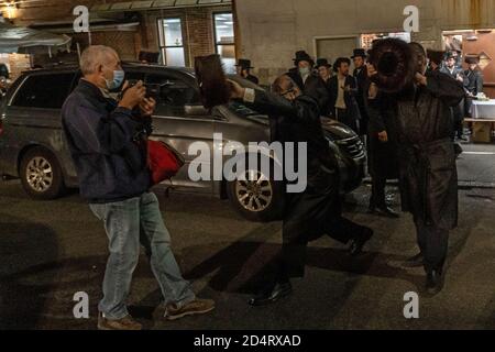 NEW YORK, NEW YORK - LE 10 OCTOBRE 2020 : des juifs orthodoxes sont confrontés à un journaliste dans le quartier de Borough Park à Brooklyn. Banque D'Images