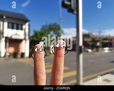 Deux doigts sont décorés pour deux personnes. Ils sont énervés par la pollution sonore continue. Banque D'Images