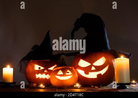 Citrouilles d'Halloween Jack O Lantern avec chapeau de sorcières, araignées et bougies allumées Banque D'Images