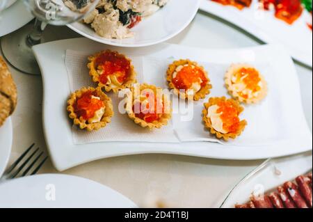 Gros plan de tartelettes appétissantes avec caviar sur une assiette blanche. Banque D'Images