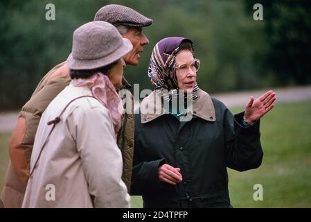 La reine Elizabeth II, portant un foulard et une veste cirée verte, en conversation au Royal Windsor Horse Show. 13 mai 1989 Banque D'Images