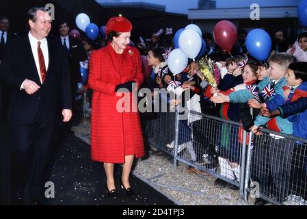 Une HRH souriante Reine Elizabeth II entourée d'enfants heureux et enthousiastes à l'ouverture de la nouvelle bibliothèque du Queen Mary College. Londres, Angleterre, Royaume-Uni. Circa1988 Banque D'Images