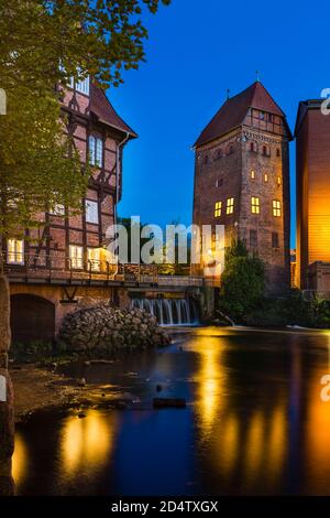 Ancien moulin et tour à la rivière Ilmenau dans la vieille ville de Lueneburg, Allemagne avec ciel bleu de nuit. Banque D'Images