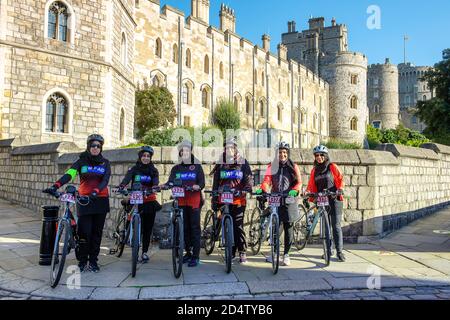 Windsor, Berkshire, Royaume-Uni. 11 octobre 2020. Ce matin, une fille pose pour une photo devant le château de Windsor alors qu'elle participe à une promenade en vélo parrainée par un organisme de bienfaisance de Stanmore à Windsor, en recueillant des fonds pour l'organisme international de bienfaisance WF-Aid. Vingt nouveaux cas de Covid-19 ont été signalés au cours des 24 dernières heures dans le quartier royal de Windsor et Maidenhead. Le gouvernement devrait annoncer un nouveau système de verrouillage à trois niveaux pour l'Angleterre après une deuxième pointe dans les cas positifs. Crédit : Maureen McLean/Alay Banque D'Images