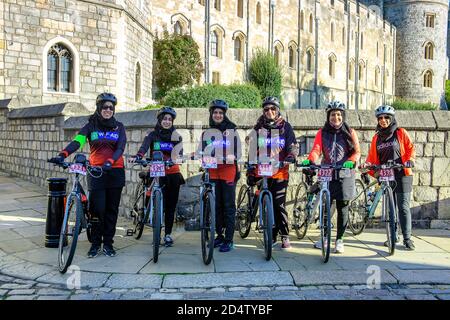 Windsor, Berkshire, Royaume-Uni. 11 octobre 2020. Ce matin, une fille pose pour une photo devant le château de Windsor alors qu'elle participe à une promenade en vélo parrainée par un organisme de bienfaisance de Stanmore à Windsor, en recueillant des fonds pour l'organisme international de bienfaisance WF-Aid. Vingt nouveaux cas de Covid-19 ont été signalés au cours des 24 dernières heures dans le quartier royal de Windsor et Maidenhead. Le gouvernement devrait annoncer un nouveau système de verrouillage à trois niveaux pour l'Angleterre après une deuxième pointe dans les cas positifs. Crédit : Maureen McLean/Alay Banque D'Images