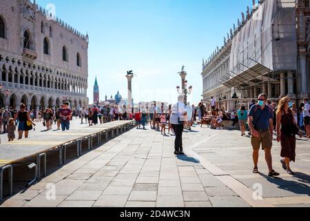 Nouveau tourisme normal à la Piazza San Marco (St. Mark's Square), Venise, Italie, pendant la pandémie du coronavirus, avec des touristes portant des masques. Banque D'Images