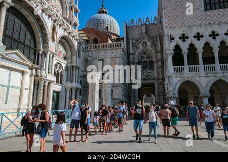 Nouveau tourisme normal à la Piazza San Marco (St. Mark's Square), Venise, Italie, pendant la pandémie du coronavirus, avec des touristes portant des masques. Banque D'Images