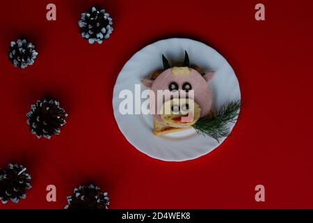 Sandwich drôle avec symbole comestible de 2021 vache à taureau fait de pain grillé, saucisse et fromage, idée de petit déjeuner pour les enfants. vacances, célébration, art de la nourriture Banque D'Images