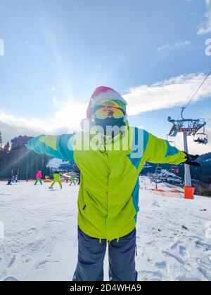 Homme heureux en tenue de ski avec le père Noël Noël rouge hat au winter mountains hill Banque D'Images