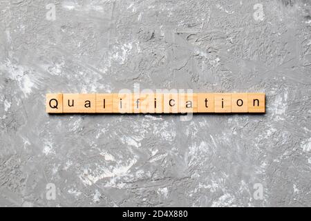 Mot de qualification écrit sur la cale en bois. qualification texte sur table, concept. Banque D'Images