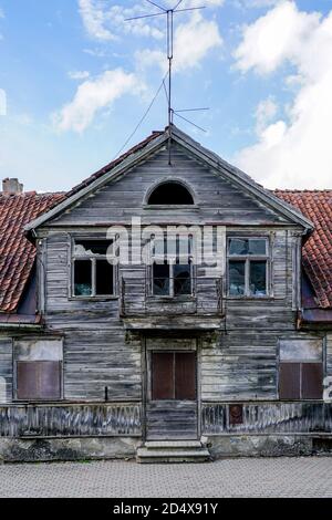 fragment de la façade d'une ancienne maison en bois avec un toit en argile sur fond bleu ciel Banque D'Images