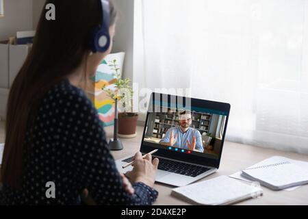 Jeune étudiante consultant en ligne avec professeur. Banque D'Images