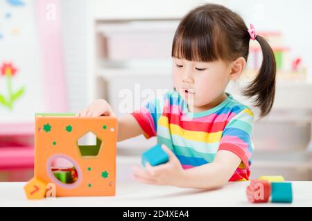 jeune fille jouant des blocs de forme de nombre pour homeschooling Banque D'Images