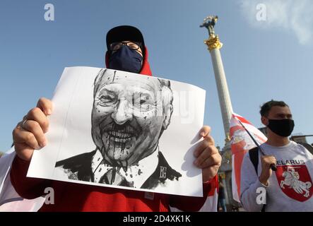 Un manifestant tient un écriteau représentant le président biélorusse Alexandre Loukachenko pendant la manifestation.des citoyens biélorusses vivant en Ukraine et des militants ukrainiens ont participé au rassemblement pour exprimer leur solidarité avec le mouvement de protestation en Biélorussie contre les résultats des élections présidentielles. Banque D'Images