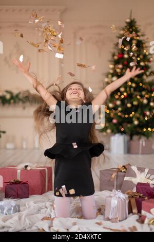 Petites filles jetés confetti. Magie de Noël. Des moments joyeux d'une enfance heureuse. Banque D'Images