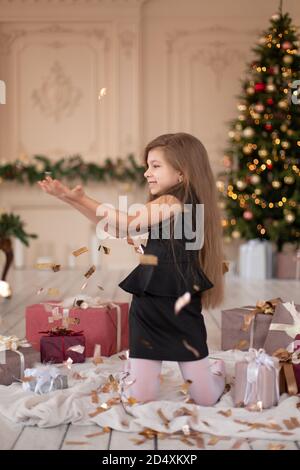 Petites filles jetés confetti. Magie de Noël. Des moments joyeux d'une enfance heureuse. Banque D'Images