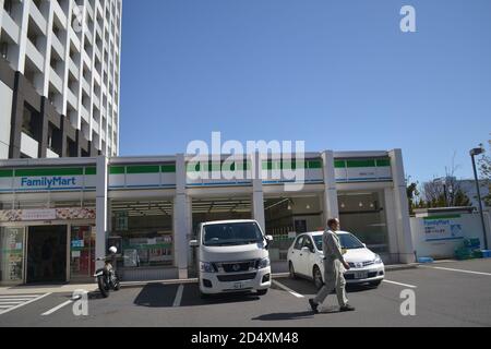 Tokyo, Japon-2/29/16: Par une journée ensoleillée, un homme est vu marcher dans un parking japonais Family Mart (Japanese commode Store). Banque D'Images